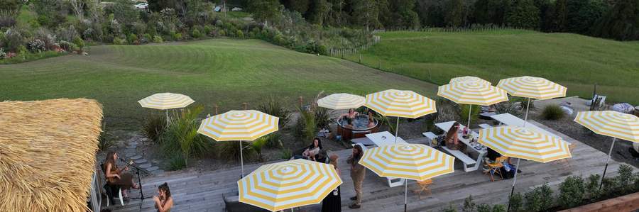 Tubby hot tubs on commercial duty among striped umbrellas at Tiki Beach, Mangawhai